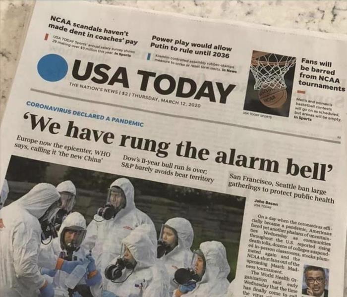 Image shows the cover of USA today featuring a SERVPRO team dressed in PPE.