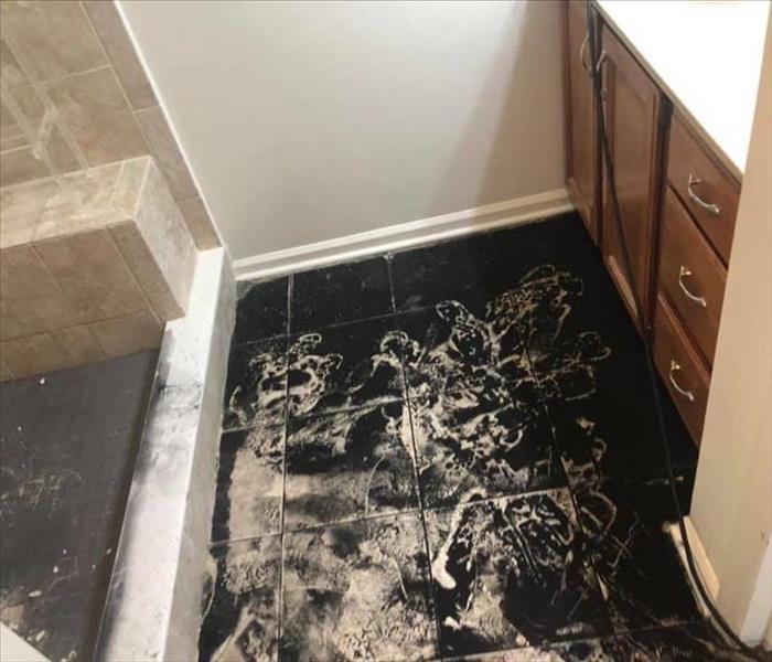 Image shows black soot covering a tile floor.
